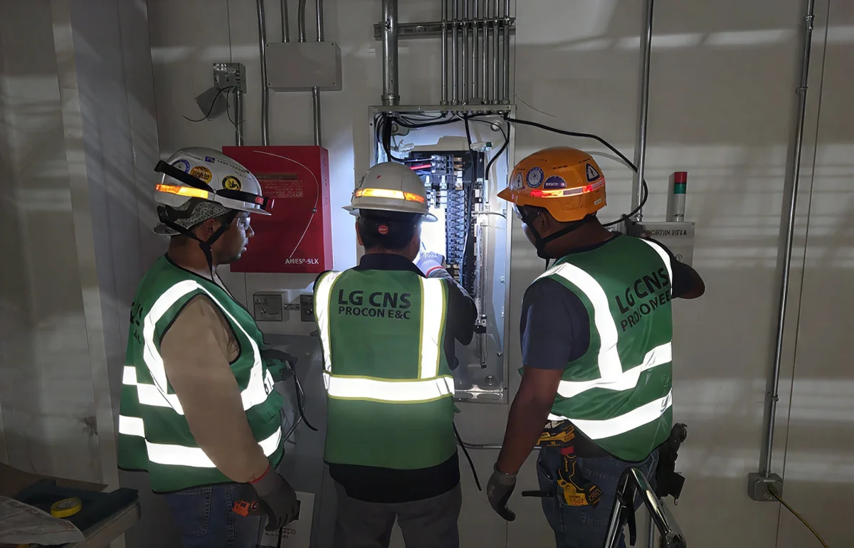 Crew members reviewing an electrical panel on site